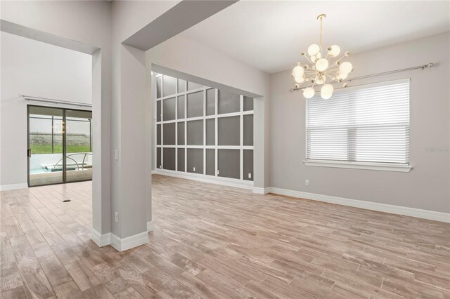 1272 Patterson Ter, Lake Mary, FL 32746 - spare room featuring a chandelier, light wood-type flooring, and baseboards
