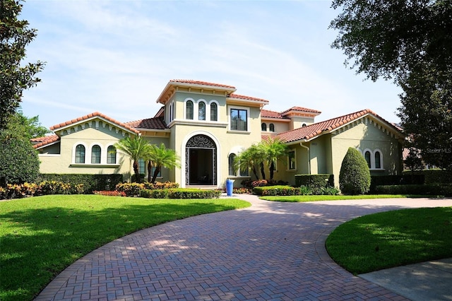 11013 Ullswater Ln, Windermere, FL 34786 - mediterranean / spanish home with stucco siding, a tiled roof, a front yard, and curved driveway