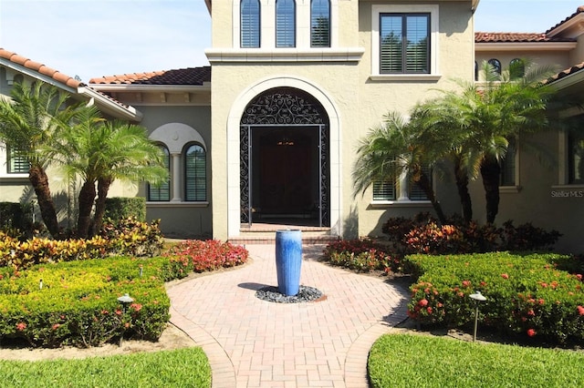 11013 Ullswater Ln, Windermere, FL 34786 - view of exterior entry featuring stucco siding and a tile roof