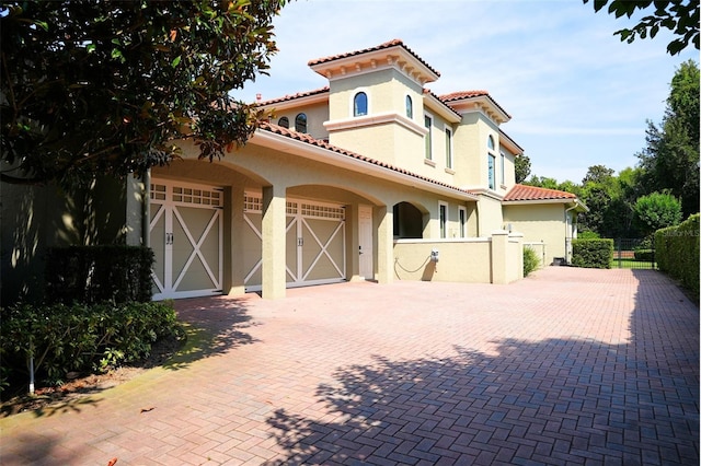 11013 Ullswater Ln, Windermere, FL 34786 - mediterranean / spanish home featuring decorative driveway, fence, a garage, stucco siding, and a tile roof