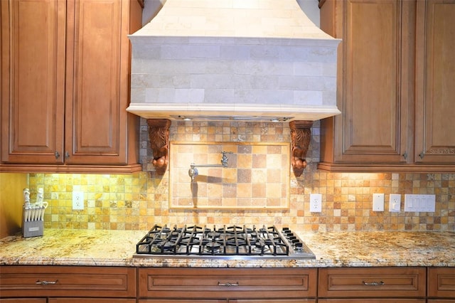11013 Ullswater Ln, Windermere, FL 34786 - kitchen featuring stainless steel gas stovetop, custom exhaust hood, brown cabinetry, and backsplash