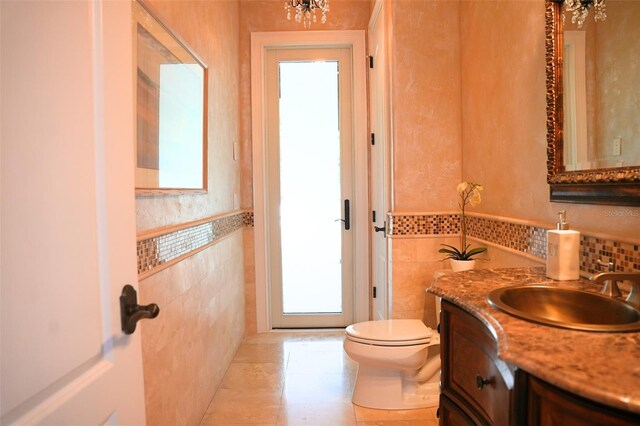 11013 Ullswater Ln, Windermere, FL 34786 - bathroom featuring tile walls, toilet, vanity, tile patterned floors, and wainscoting