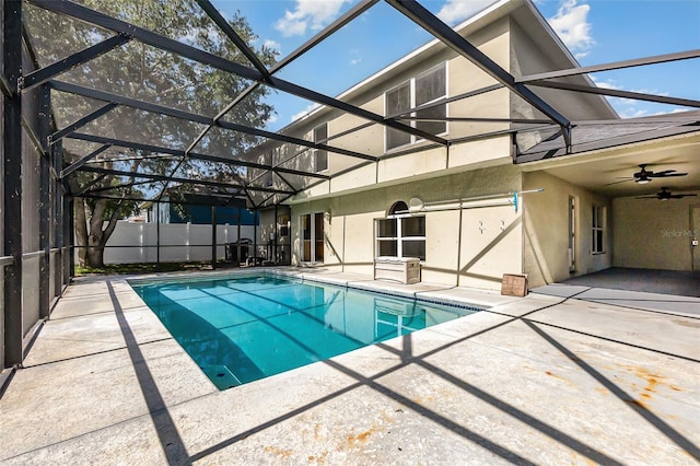 view of swimming pool featuring a patio area, a ceiling fan, and glass enclosure