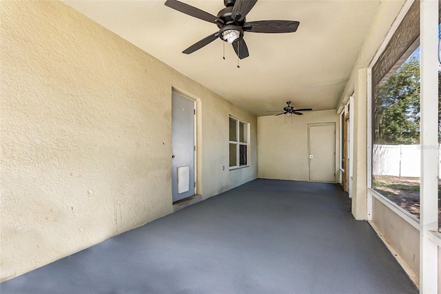 unfurnished sunroom with a ceiling fan and plenty of natural light