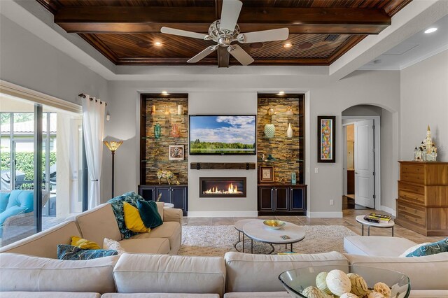 11755 Waterstone Loop Dr, Windermere, FL 34786 - living room featuring wooden ceiling, arched walkways, a ceiling fan, beam ceiling, and a glass covered fireplace
