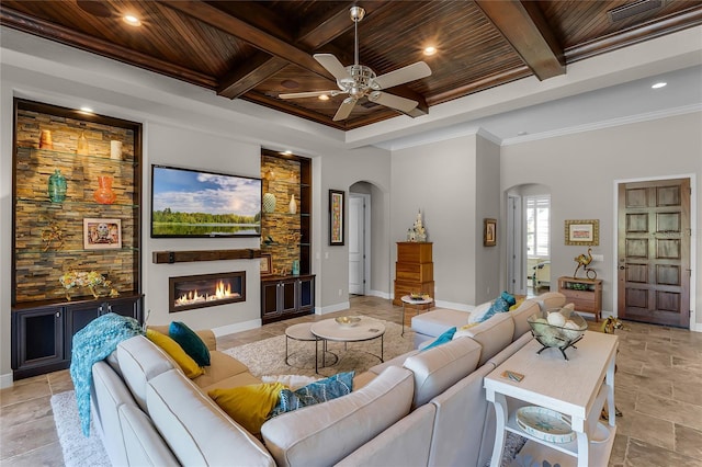11755 Waterstone Loop Dr, Windermere, FL 34786 - living room featuring arched walkways, wooden ceiling, ceiling fan, a glass covered fireplace, and beamed ceiling