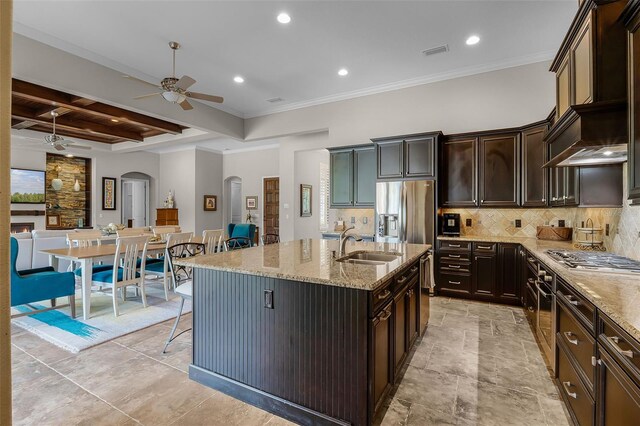 11755 Waterstone Loop Dr, Windermere, FL 34786 - kitchen with arched walkways, appliances with stainless steel finishes, a ceiling fan, a sink, and light stone countertops