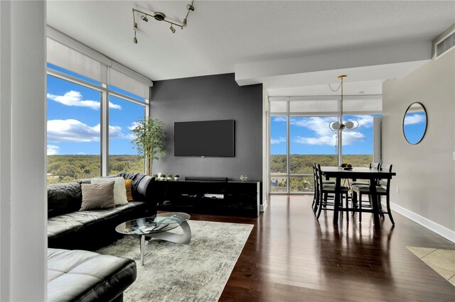 101 S Eola Dr Unit 810, Orlando, FL 32801 - living area with expansive windows, dark wood-style floors, a chandelier, and baseboards