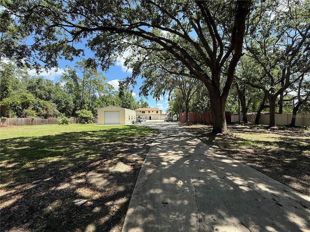 view of yard with driveway and an outbuilding