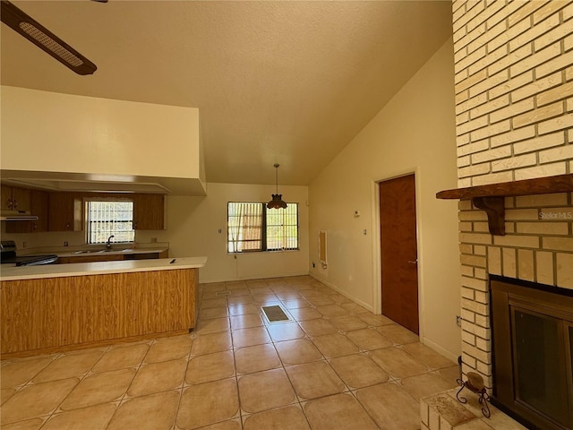 kitchen with stainless steel electric range, light tile patterned floors, healthy amount of natural light, a fireplace, and high vaulted ceiling