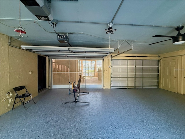 garage with a textured wall, a garage door opener, and ceiling fan