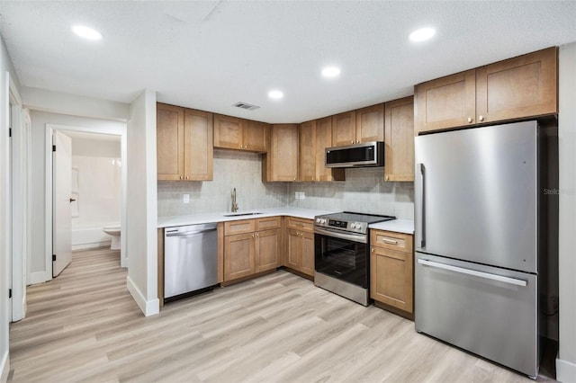 1957 Deloy Dr, Daytona Beach, FL 32119 - kitchen featuring stainless steel appliances, light countertops, light wood-style flooring, decorative backsplash, and recessed lighting