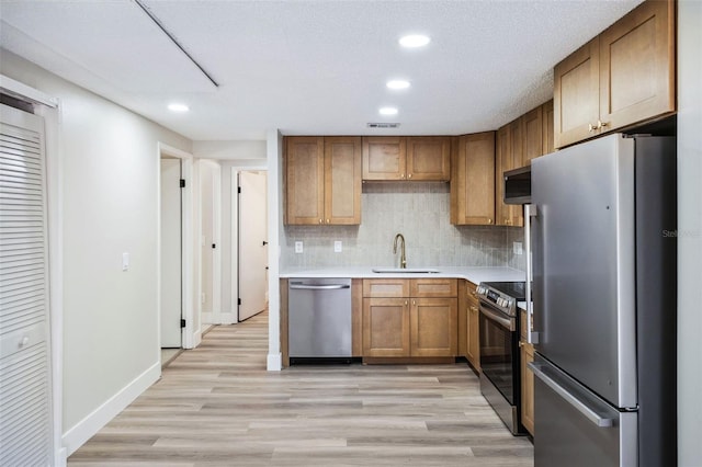 1957 Deloy Dr, Daytona Beach, FL 32119 - kitchen featuring appliances with stainless steel finishes, light wood-style floors, recessed lighting, light countertops, and a sink