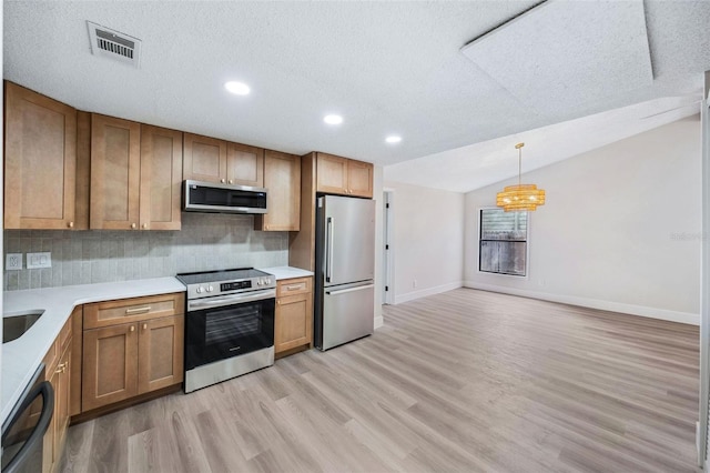 1957 Deloy Dr, Daytona Beach, FL 32119 - kitchen featuring stainless steel appliances, light wood-type flooring, decorative backsplash, baseboards, and a textured ceiling