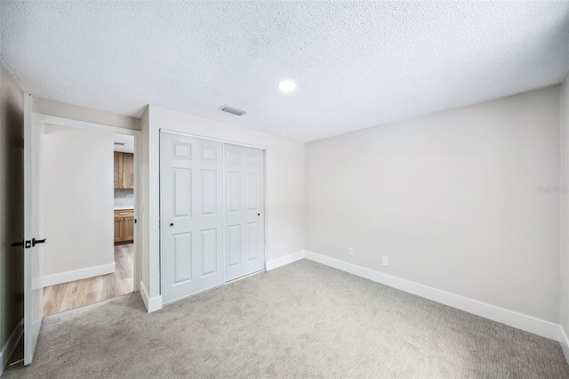 1957 Deloy Dr, Daytona Beach, FL 32119 - unfurnished bedroom featuring carpet floors, baseboards, a closet, a textured ceiling, and recessed lighting