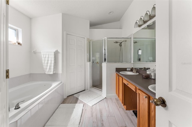 9563 Myrtle Creek Ln, Orlando, FL 32832 - bathroom with a stall shower, a garden tub, double vanity, wood finished floors, and a textured ceiling