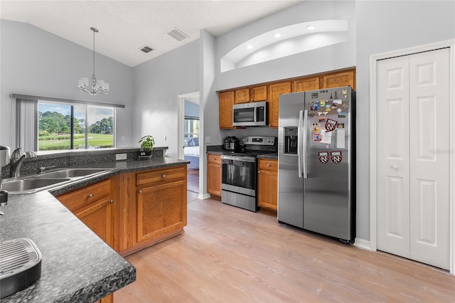 9563 Myrtle Creek Ln, Orlando, FL 32832 - kitchen featuring stainless steel appliances, a sink, high vaulted ceiling, brown cabinetry, and a chandelier