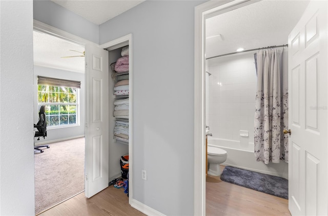 9563 Myrtle Creek Ln, Orlando, FL 32832 - bathroom with wood finished floors, toilet, shower / tub combo, baseboards, and a textured ceiling
