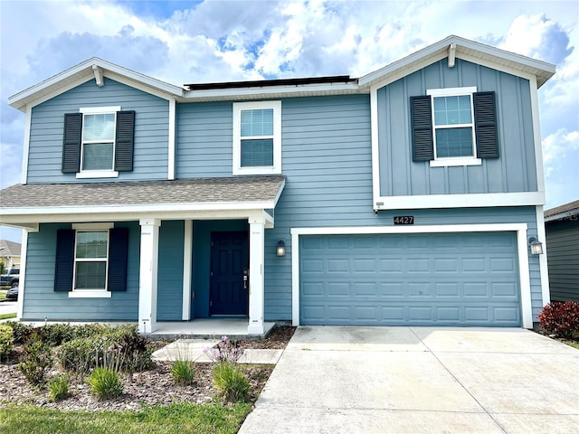 4427 Blackbird St, Kissimmee, FL 34746 - view of front of home featuring a porch, concrete driveway, board and batten siding, an attached garage, and a shingled roof