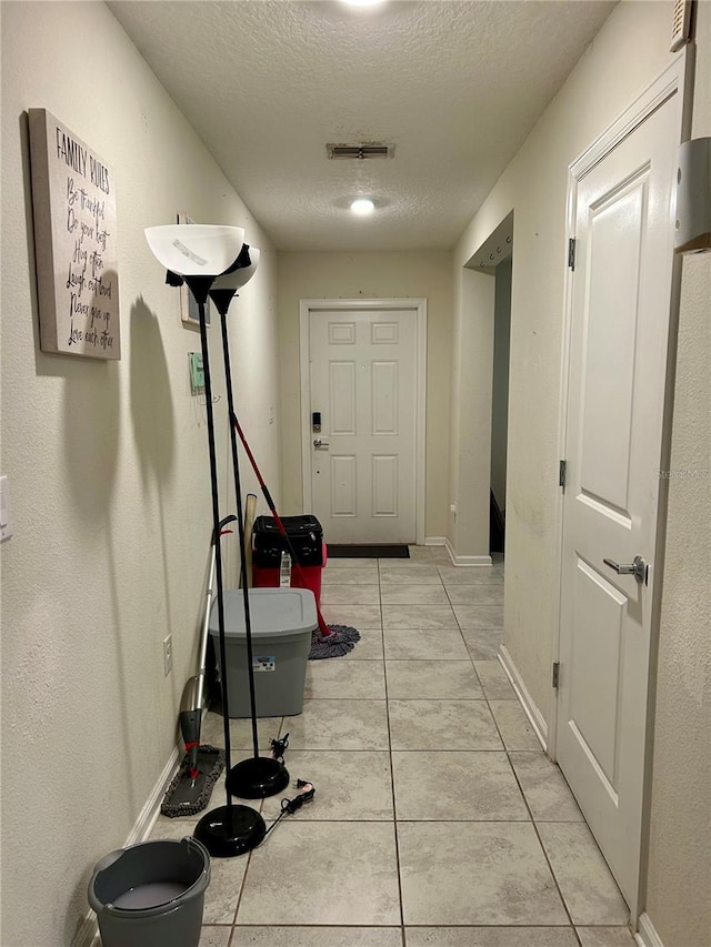 4427 Blackbird St, Kissimmee, FL 34746 - corridor featuring a textured ceiling, baseboards, and light tile patterned floors