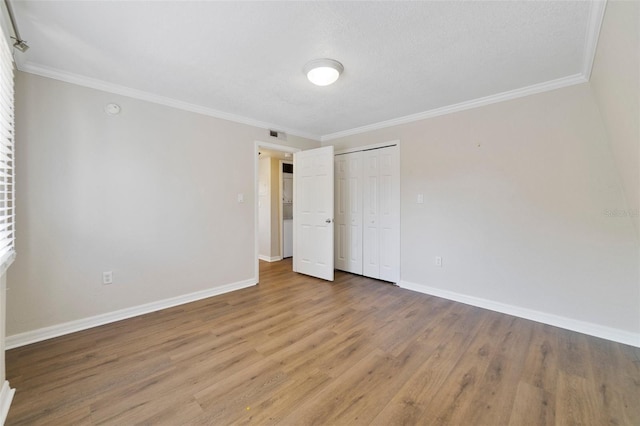 1948 Conway Rd Unit 8, Orlando, FL 32812 - unfurnished bedroom with baseboards, light wood finished floors, crown molding, and a closet