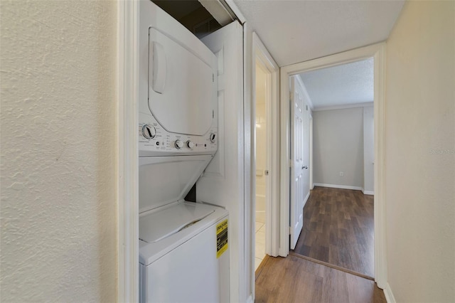 1948 Conway Rd Unit 8, Orlando, FL 32812 - clothes washing area with stacked washer / dryer, wood finished floors, a textured wall, and baseboards