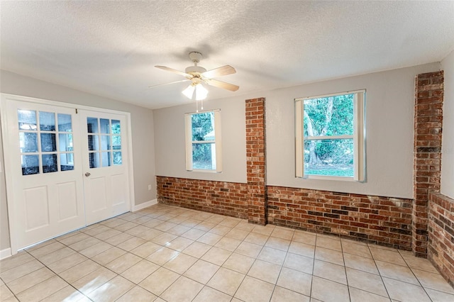 635 San Lanta Cir, Sanford, FL 32771 - empty room with brick wall, ceiling fan, light tile patterned floors, and a textured ceiling