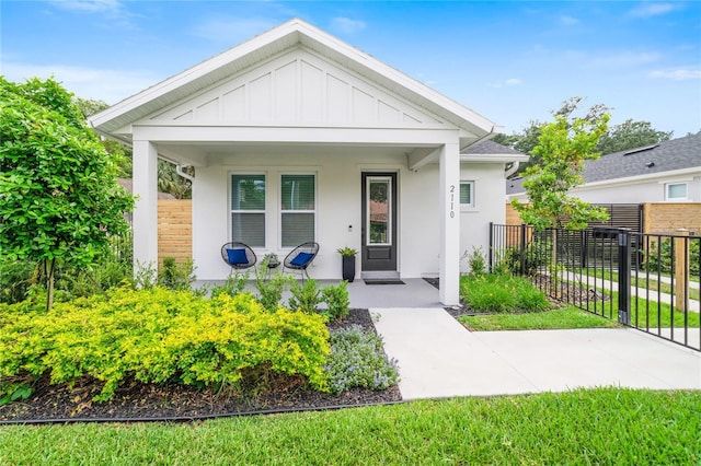 2110 Hillcrest St, Orlando, FL 32803 - view of front of home featuring covered porch, board and batten siding, fence, and stucco siding