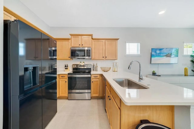 2110 Hillcrest St, Orlando, FL 32803 - kitchen featuring stainless steel appliances, a sink, a peninsula, light tile patterned flooring, and light countertops
