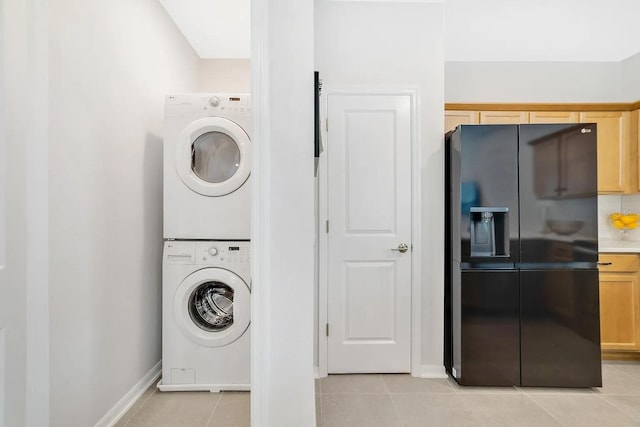 2110 Hillcrest St, Orlando, FL 32803 - clothes washing area with stacked washer and clothes dryer, light tile patterned floors, and baseboards