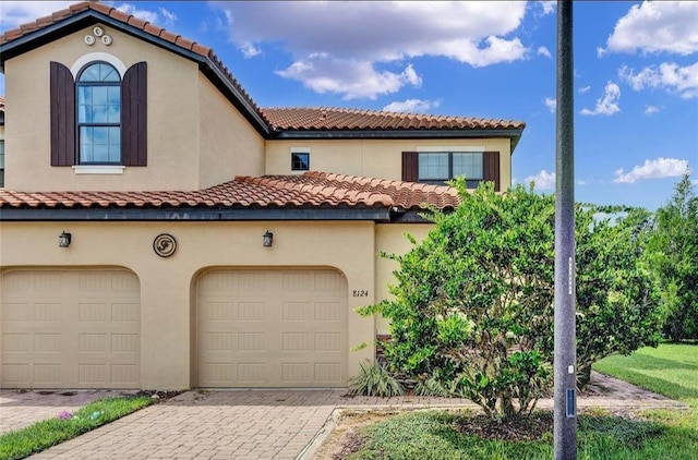 8124 Roseville Rd, Davenport, FL 33896 - mediterranean / spanish-style house with a garage, decorative driveway, stucco siding, and a tiled roof