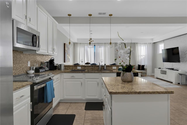 8124 Roseville Rd, Davenport, FL 33896 - kitchen featuring stainless steel appliances, a sink, open floor plan, and decorative backsplash