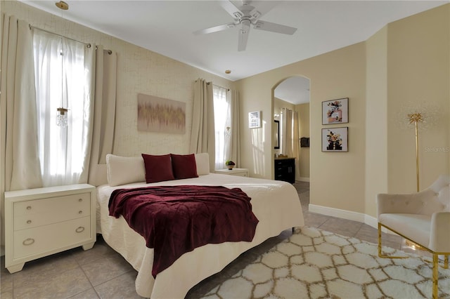 8124 Roseville Rd, Davenport, FL 33896 - bedroom with multiple windows, arched walkways, light tile patterned flooring, and baseboards