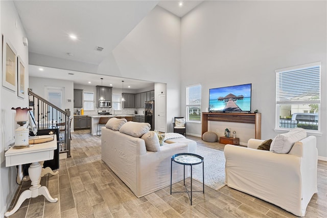 15358 Arcadia Bluff Loop, Winter Garden, FL 34787 - living room featuring wood finish floors, stairs, a towering ceiling, baseboards, and recessed lighting