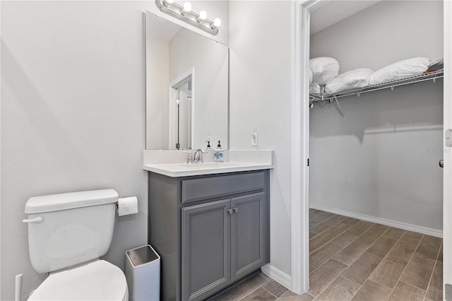 15358 Arcadia Bluff Loop, Winter Garden, FL 34787 - bathroom with toilet, wood tiled floors, vanity, a walk in closet, and baseboards