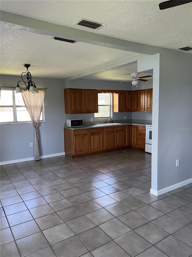 14330 Ellerbee St, Winter Garden, FL 34787 - kitchen featuring white appliances, a textured ceiling, ceiling fan, baseboards, and light countertops