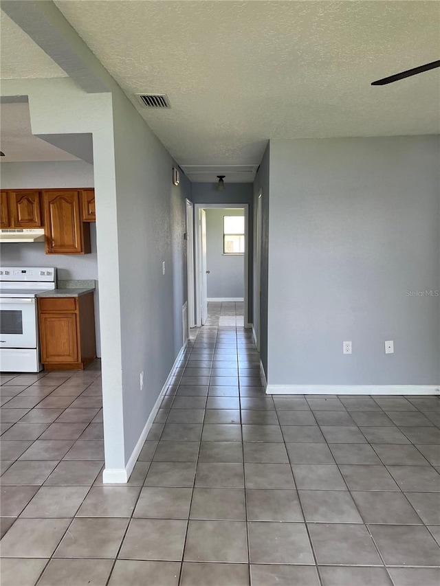 14330 Ellerbee St, Winter Garden, FL 34787 - hallway featuring a textured ceiling, light tile patterned floors, and baseboards