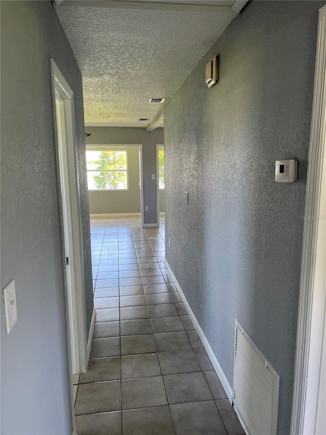 14330 Ellerbee St, Winter Garden, FL 34787 - hall featuring tile patterned flooring, a textured wall, baseboards, and a textured ceiling