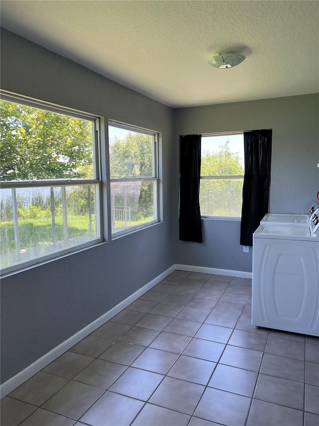 14330 Ellerbee St, Winter Garden, FL 34787 - laundry area featuring healthy amount of natural light, a textured ceiling, washer and dryer, light tile patterned floors, and baseboards