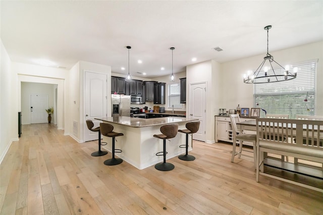 1089 Seburn Rd, Apopka, FL 32703 - kitchen with stainless steel appliances, a breakfast bar, healthy amount of natural light, light wood-style flooring, and recessed lighting
