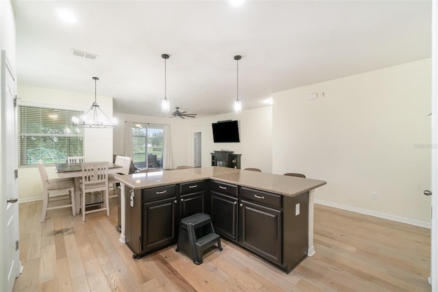 1089 Seburn Rd, Apopka, FL 32703 - kitchen with light wood-style flooring, light countertops, baseboards, decorative light fixtures, and a kitchen island