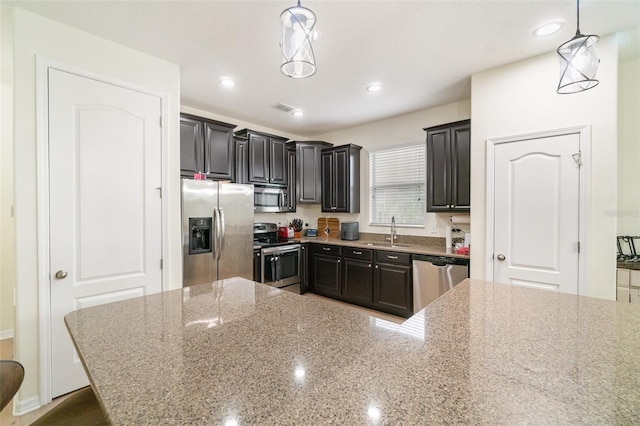 1089 Seburn Rd, Apopka, FL 32703 - kitchen with appliances with stainless steel finishes, light stone counters, a sink, recessed lighting, and decorative light fixtures