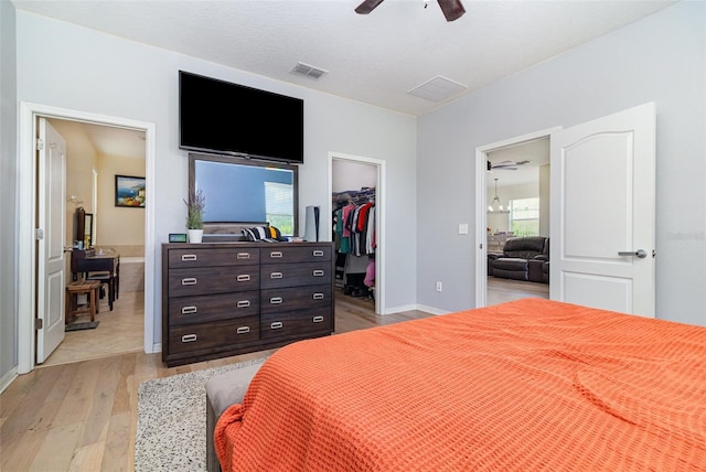 1089 Seburn Rd, Apopka, FL 32703 - bedroom featuring light wood-type flooring, a walk in closet, a closet, ceiling fan, and baseboards
