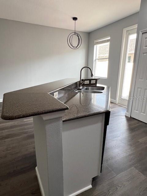 14531 Pleach St, Winter Garden, FL 34787 - kitchen featuring dark wood-style floors, dark stone counters, and hanging light fixtures