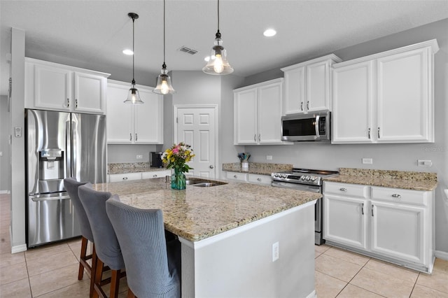 646 Marsh Reed Dr, Winter Garden, FL 34787 - kitchen with appliances with stainless steel finishes, light tile patterned flooring, recessed lighting, an island with sink, and white cabinetry
