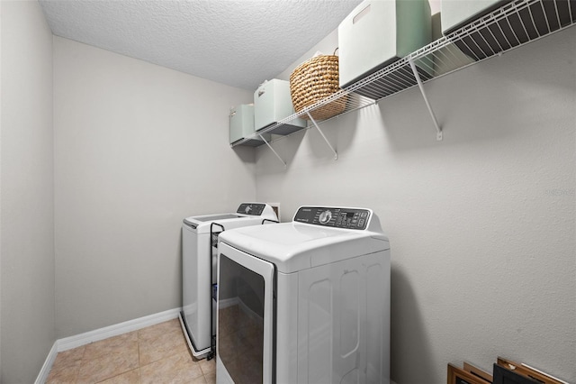 646 Marsh Reed Dr, Winter Garden, FL 34787 - laundry room featuring washer and dryer, a textured ceiling, and light tile patterned floors