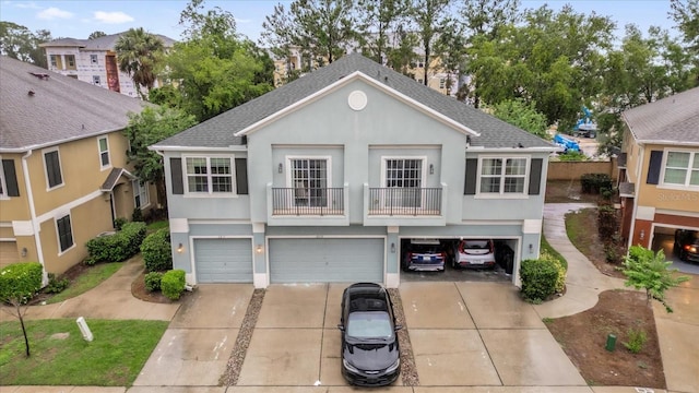 2810 San Jacinto Cir Unit 2810, Sanford, FL 32771 - view of front of property with concrete driveway, a garage, roof with shingles, stucco siding, and a balcony