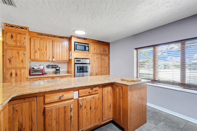 106 8th St, Lake Hamilton, FL 33851 - kitchen featuring stainless steel appliances, baseboards, tile patterned flooring, a textured ceiling, and light stone counters