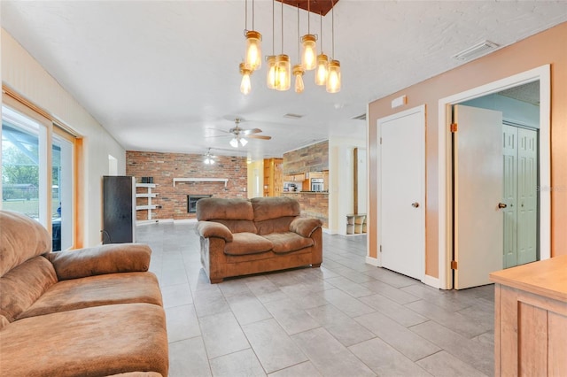 106 8th St, Lake Hamilton, FL 33851 - living area with brick wall, a ceiling fan, a brick fireplace, light tile patterned flooring, and a chandelier