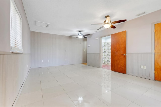 106 8th St, Lake Hamilton, FL 33851 - empty room featuring attic access, wainscoting, a ceiling fan, light tile patterned floors, and wooden walls